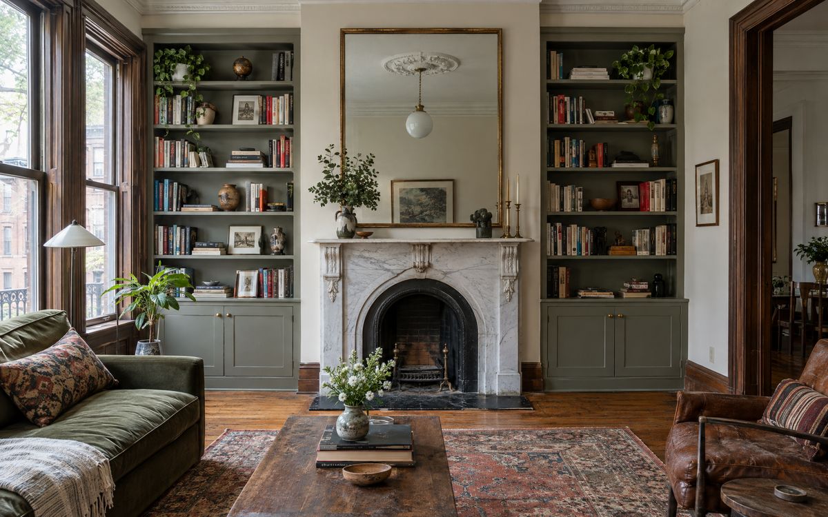 Built-in bookcases on both sides of a marble fireplace in a Park Slope brownstone parlor, design concept