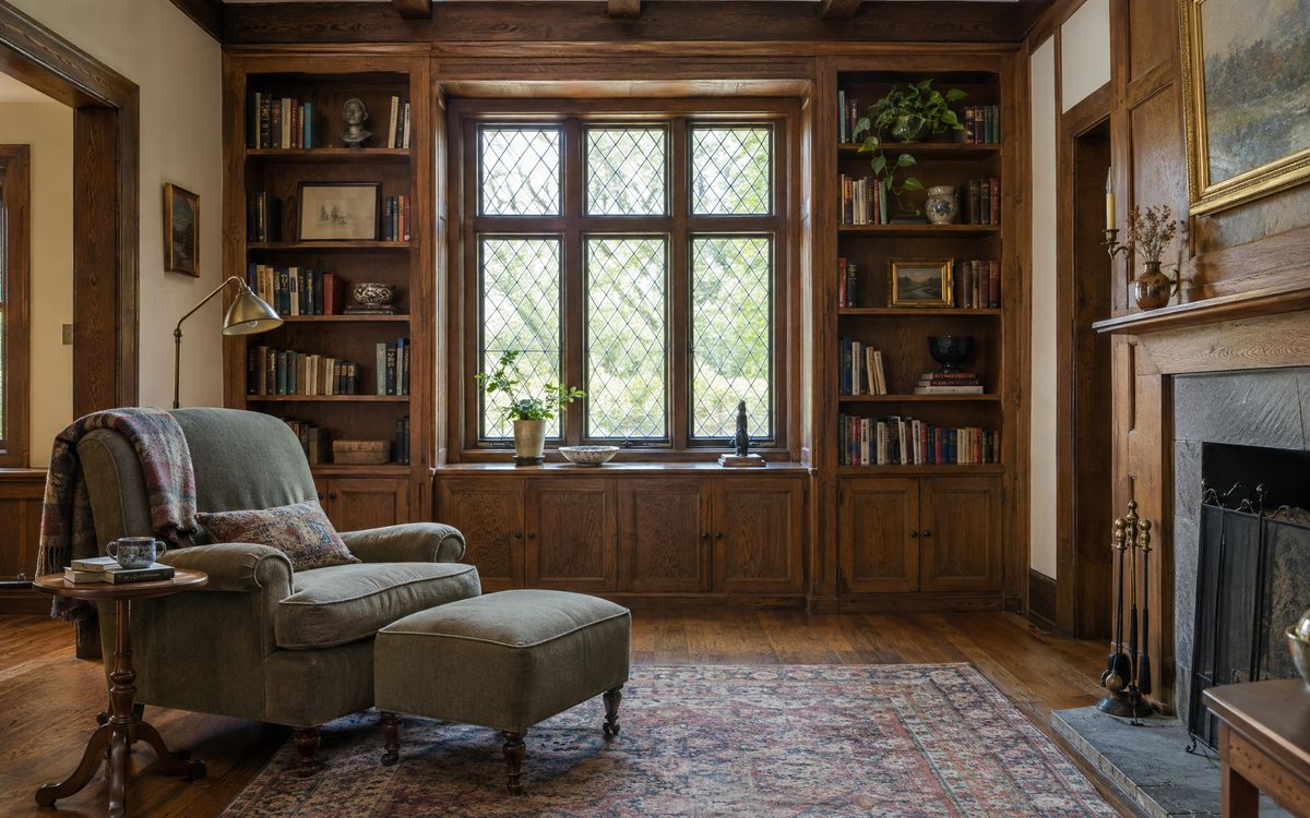 Built-in oak bookcases around a leaded window in a Tudor-style Forest Hills den, design concept
